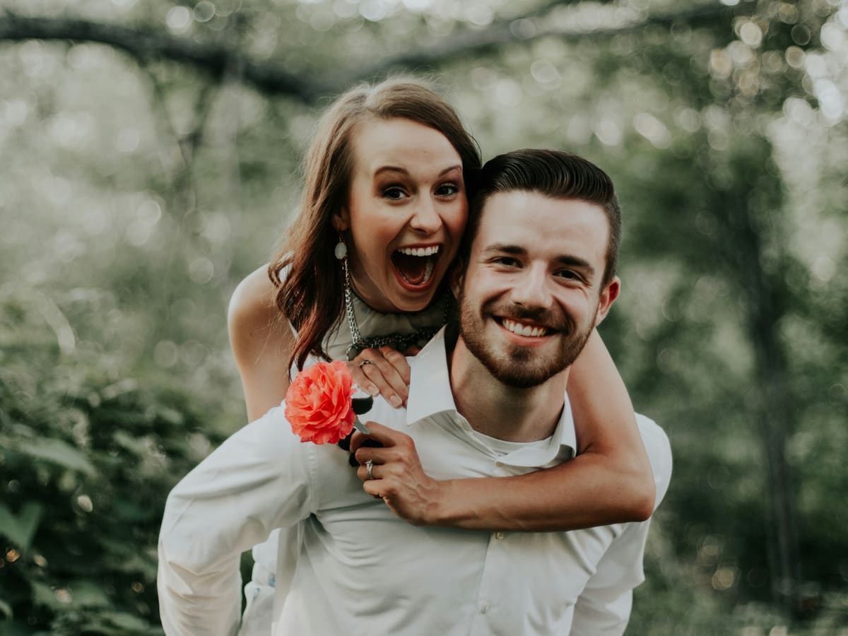 A joyful engaged couple laughing together outdoors
